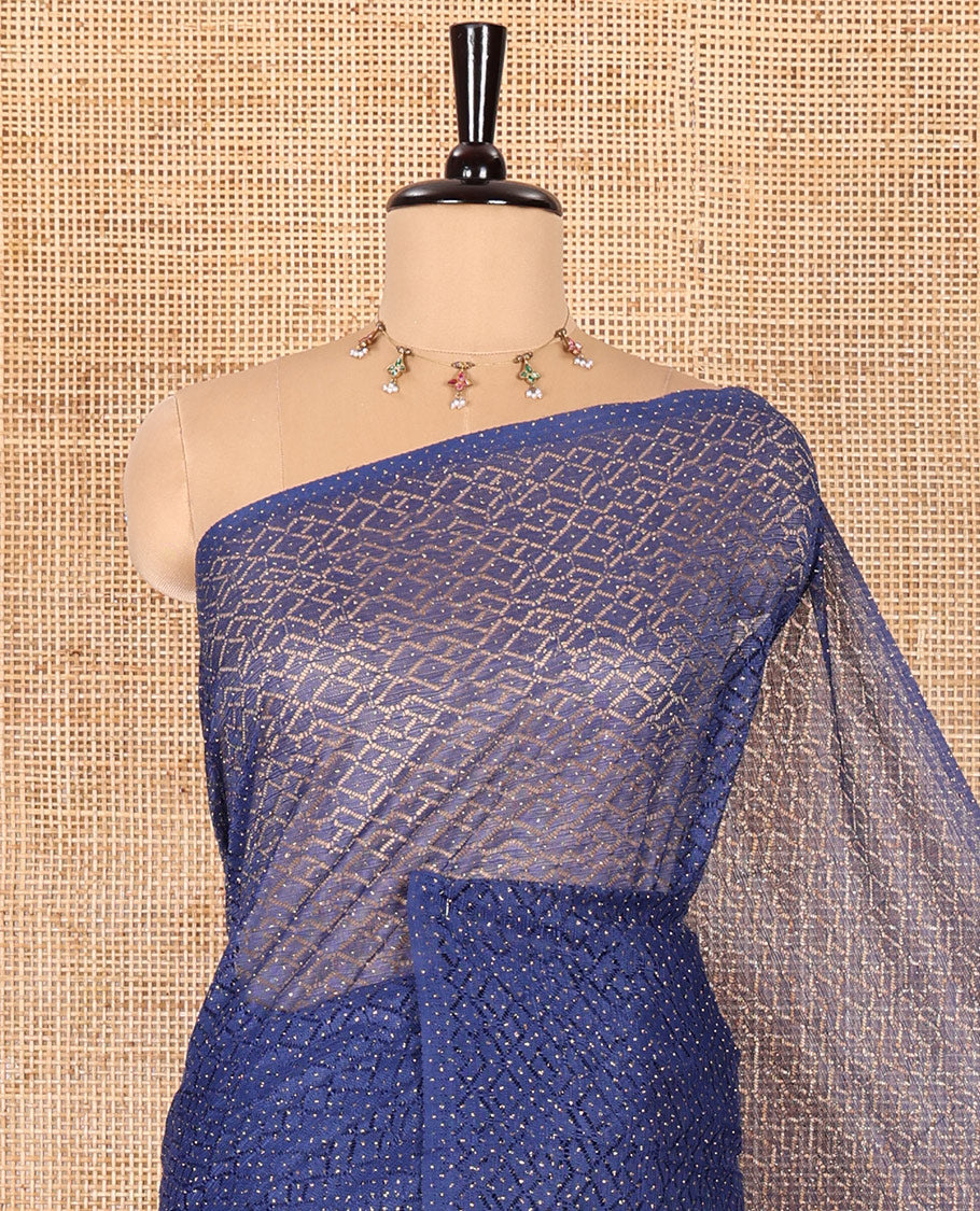 Borderless navy blue sparkling glitter russel net saree with self-pallu, and a contrast floral printed and zig-zag patterned blouse