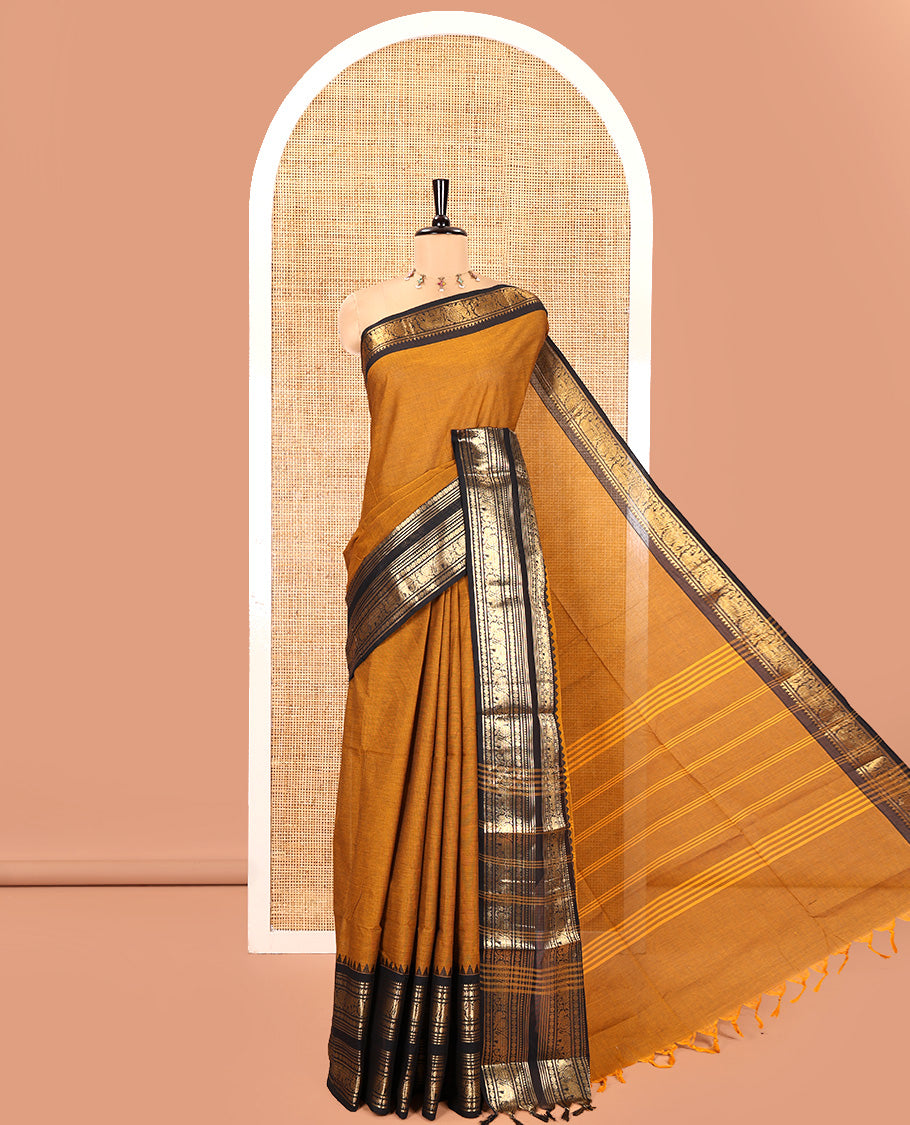 Mustard Plain Chettinad Cotton Saree, Complemented by a Contrast Rettai Pettu Temple Sliver-Sheen-Gold Zari Border of Coin, Elephant, and Peacock Designs, Subtly Striped Pallu, and Paired with a Matching Blouse