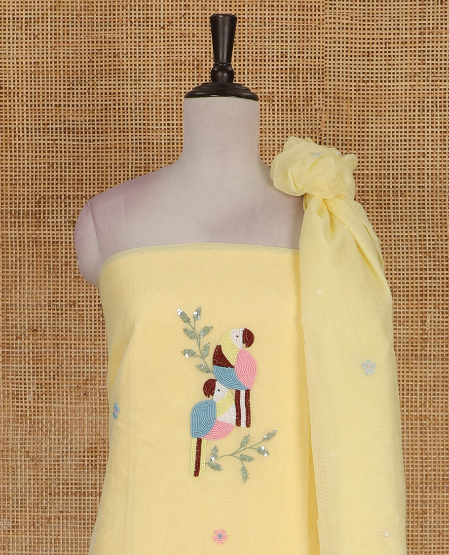 Yellow net kota material chudidar set, macaw parrot, and flower motifs, multi-color sugar bead embroidered top, plain santoon bottom, and sugar bead embroidered dupatta