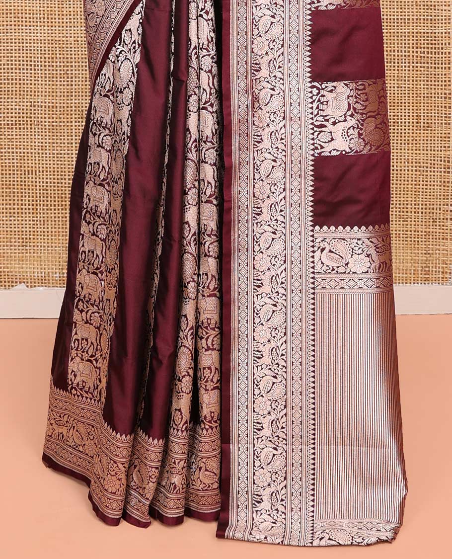 Maroon Semi-Banaras Silk Saree, Impeccably Detailed with Animal-themed Jacquard Designs on Its Body, Highlighted by a Zari Border of Traditional Designs, Pallu Steeped with Stripes, and Paired with a Matching Blouse