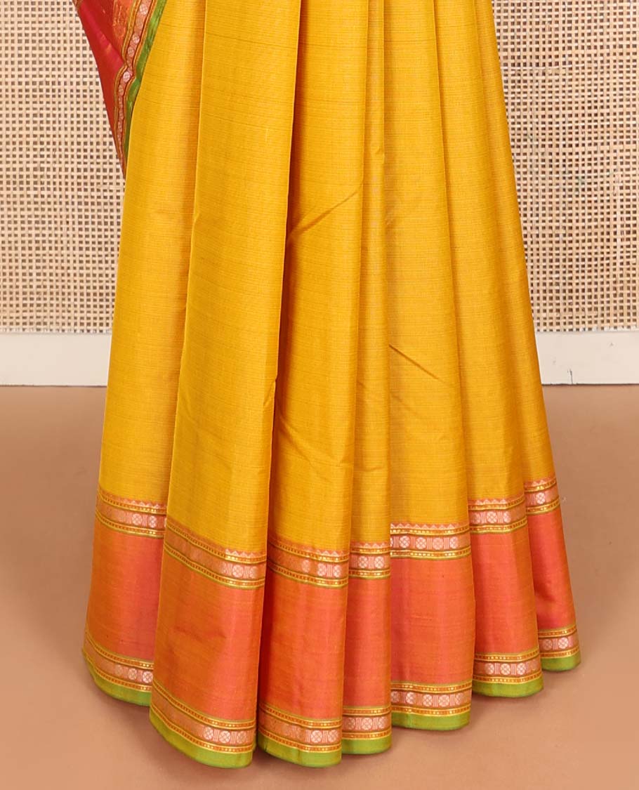 Yellow plain Kanchipuram silk saree, contrast border of rekku, muthu, rudraksham, and mayil designs, and zari striped pallu