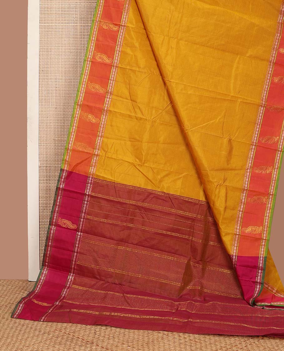 Yellow plain Kanchipuram silk saree, contrast border of rekku, muthu, rudraksham, and mayil designs, and zari striped pallu