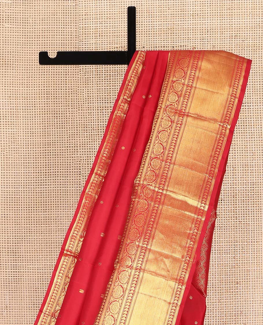 Red Kanchipuram Silk Saree, Subtly Sparkled with Zari Buttas All Over Its Body, Highlighted by a Zari Border of Thilakam, Kathir, Manga, and Dhavana Kodi Designs, Pallu of Jaal and Mayil Designs, and Paired with a Matching Blouse