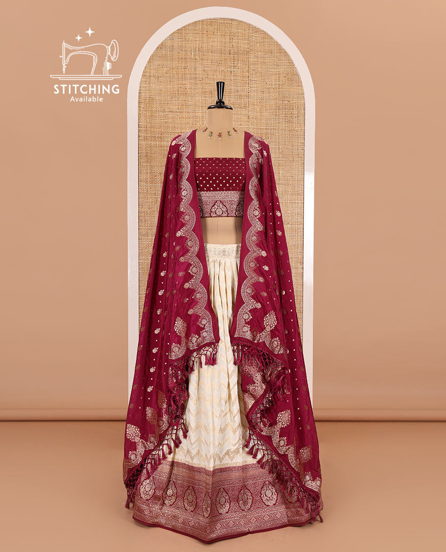 Cream-maroon chiniya crepe half-saree, chevron zari jacquard with contrast intricate patterned stone work bordered skirt, contrast blouse, and a scallop bordered intricate dhavani