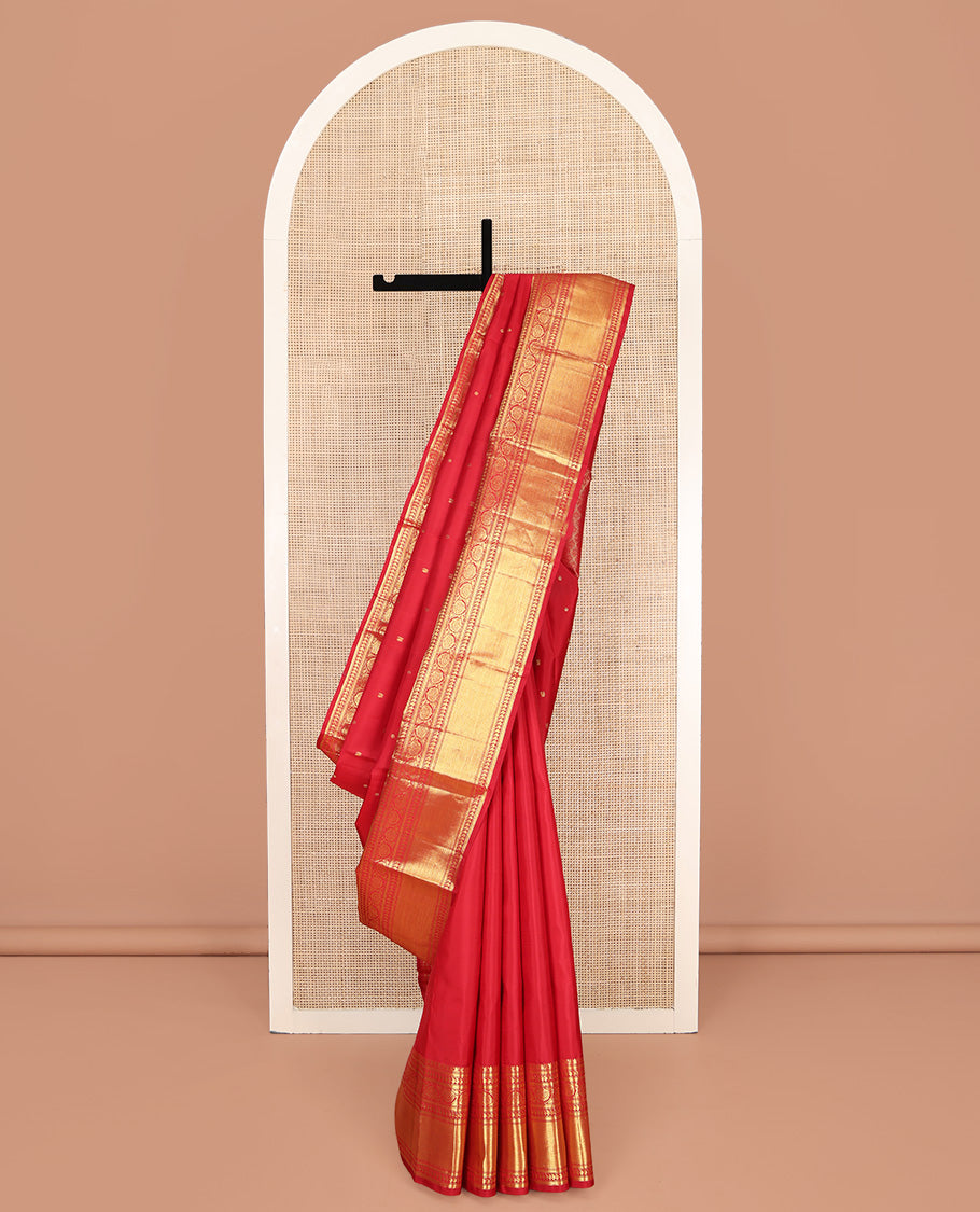 Red Kanchipuram Silk Saree, Subtly Sparkled with Zari Buttas All Over Its Body, Highlighted by a Zari Border of Thilakam, Kathir, Manga, and Dhavana Kodi Designs, Pallu of Jaal and Mayil Designs, and Paired with a Matching Blouse