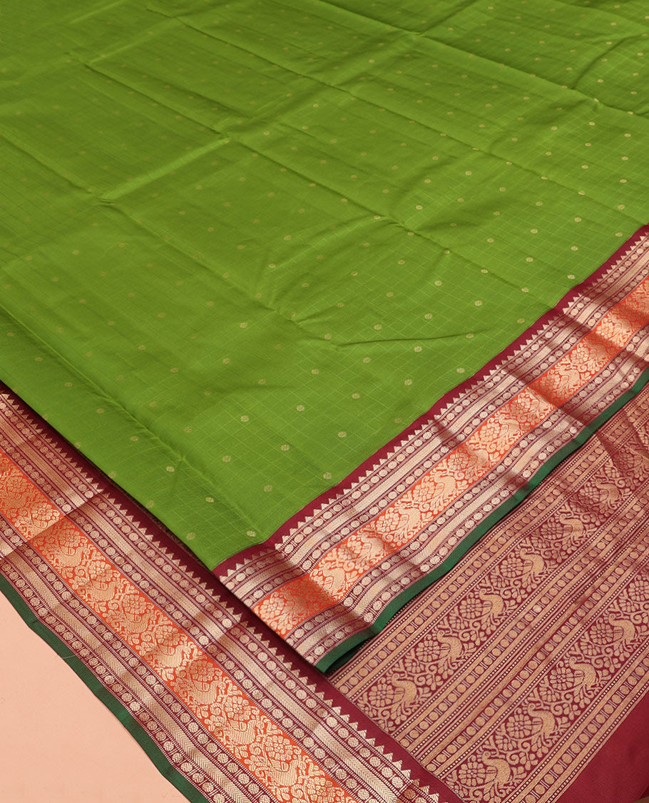 Green Vasundhara Silk Saree, Sparsely Woven with Zari Buttas All Over Its Body, Complemented by a Contrast Border of Rekku, Poun, Kathir, and Mayil Designs, Pallu Steeped with the Same Border Designs, and Paired with a Contrast Blouse