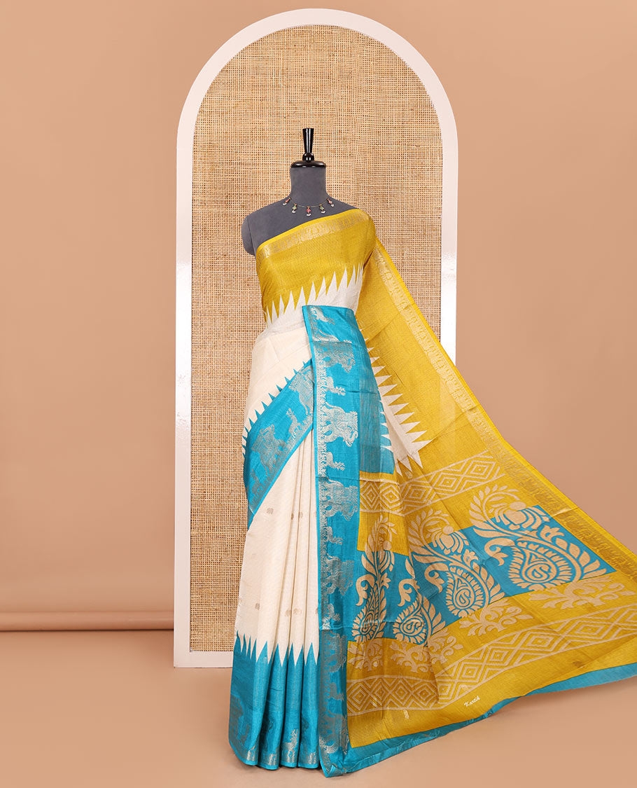 Half-white zari stripes and buttas dola silk saree, contrast yellow-blue Ganga-Jamuna temple elephant motifs border, paisleys printed pallu, and contrast elephant buttas blouse