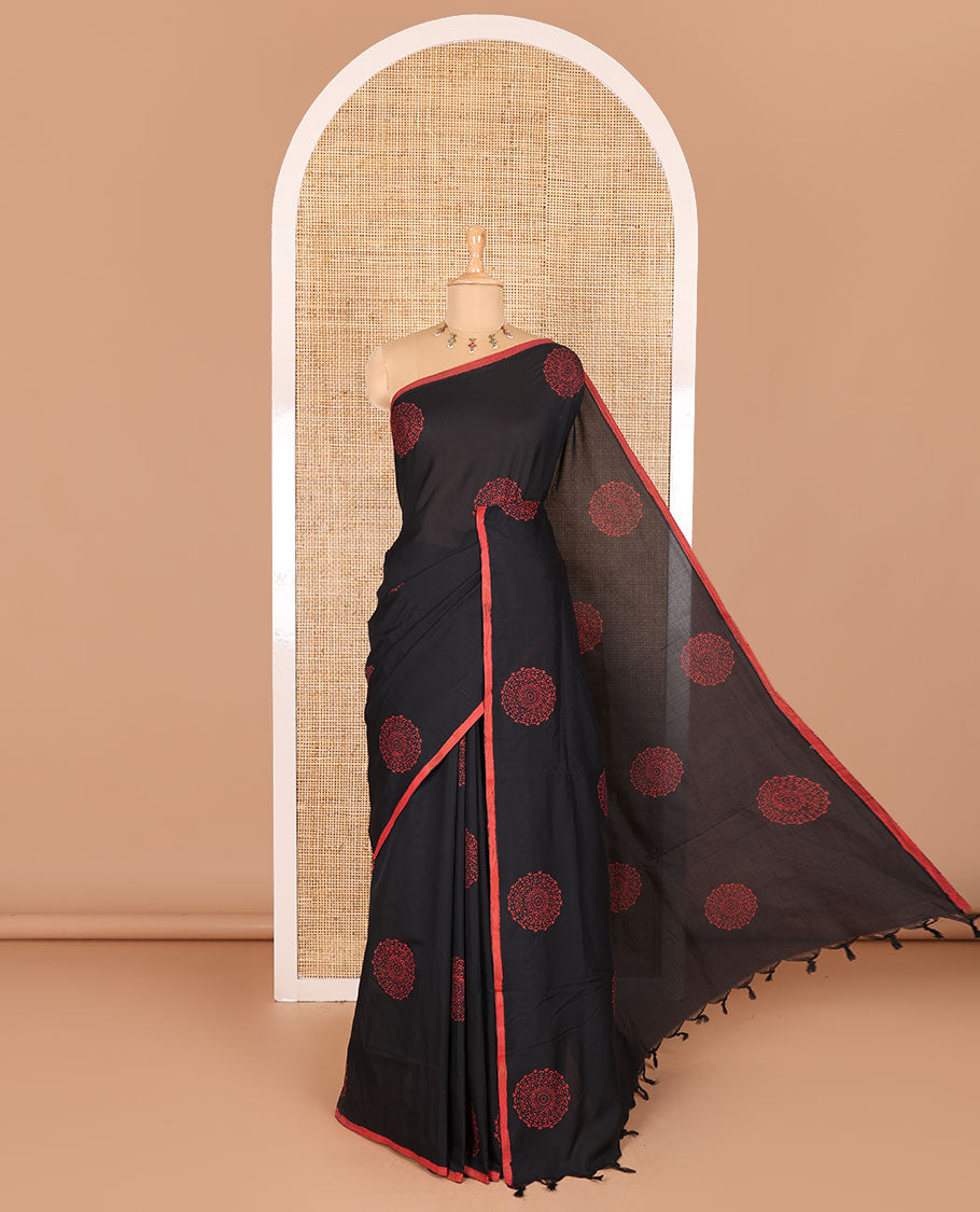 Borderless black rangoli-style chakram motifs printed South cotton saree with a matching blouse, and a contrast floral printed blouse