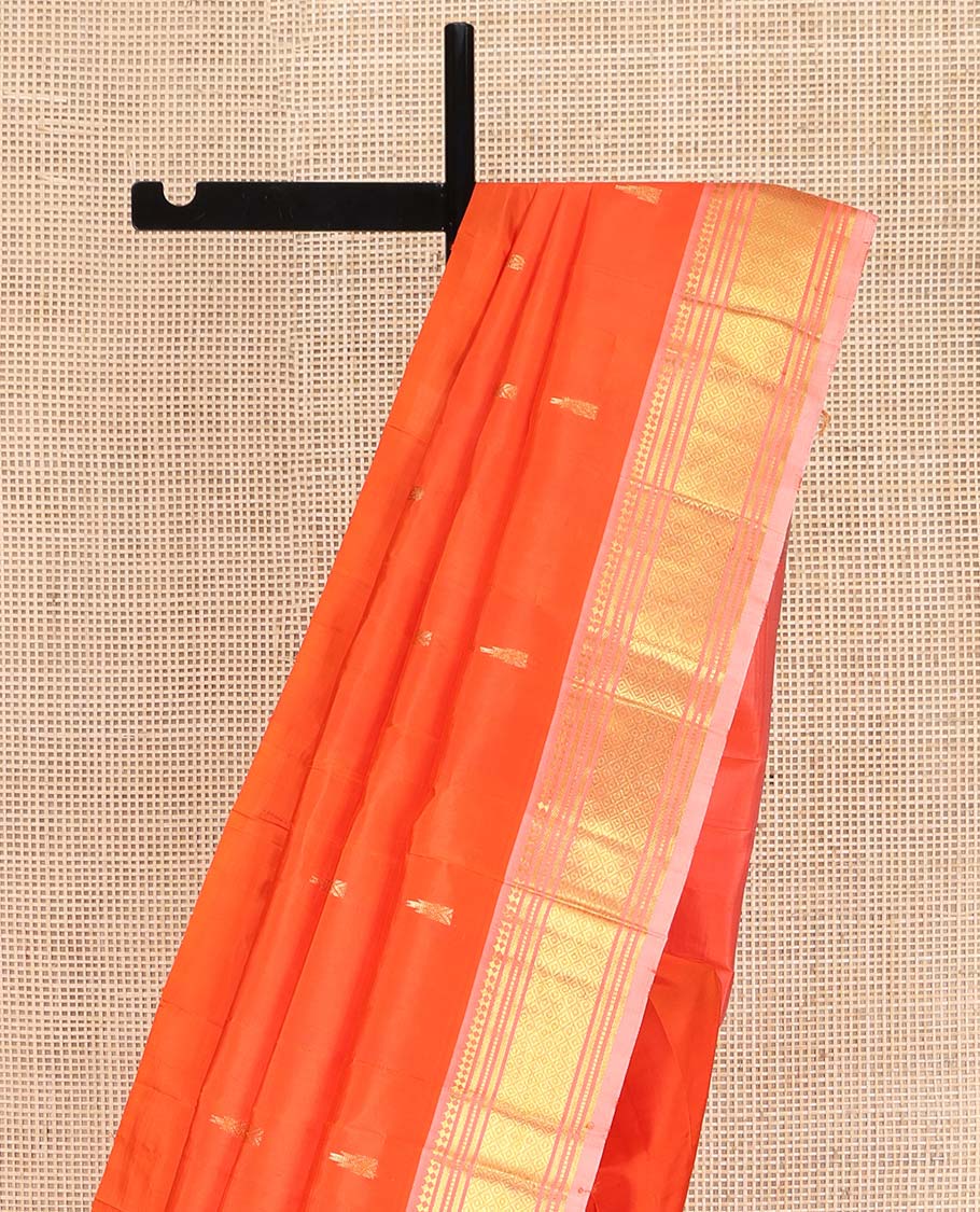 Orange Kanchipuram Silk Saree, Mesmerized with Zari Buttas on Its Body, Complemented by a Contrast One-Sided Border of Paneer Sombu, Banaras, Muthu and Mayil Kann Designs, Pallu of Zari Designs, and Comes Without a Blouse