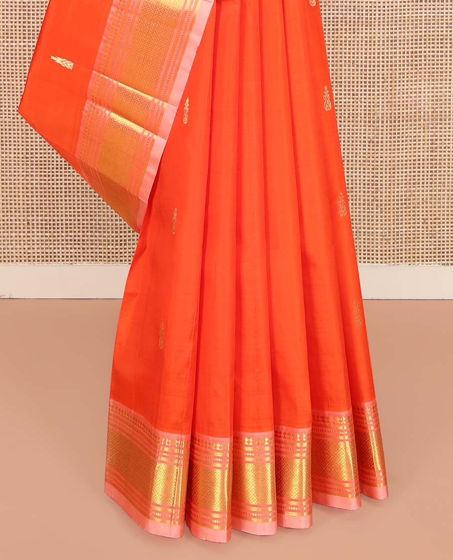 Orange Kanchipuram Silk Saree, Mesmerized with Zari Buttas on Its Body, Complemented by a Contrast One-Sided Border of Paneer Sombu, Banaras, Muthu and Mayil Kann Designs, Pallu of Zari Designs, and Comes Without a Blouse