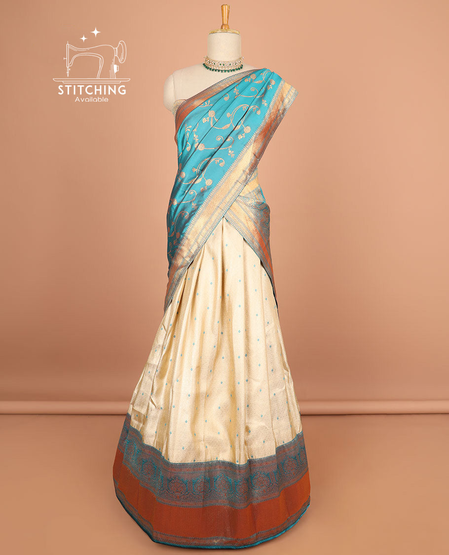 Cream motifs half saree with contrast zari design border, zari design blouse & blue floral vine zari design dhavani