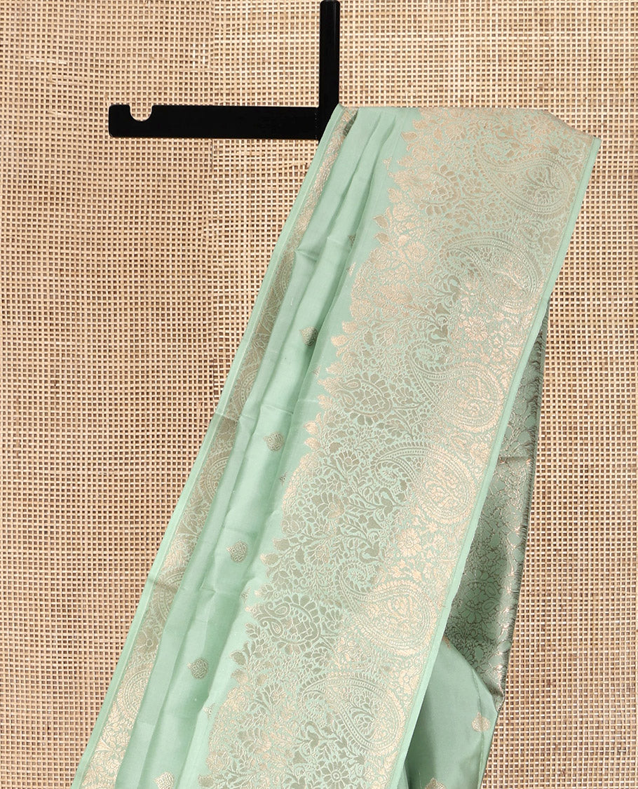 Green Kanchipuram Silk Saree, Delicately Woven with Zari Buttas All Over Its Body, Highlighted by a Zari Border of Floral and Paisley Designs, Grand Chevron Striped Pallu, and Paired with a Matching Blouse