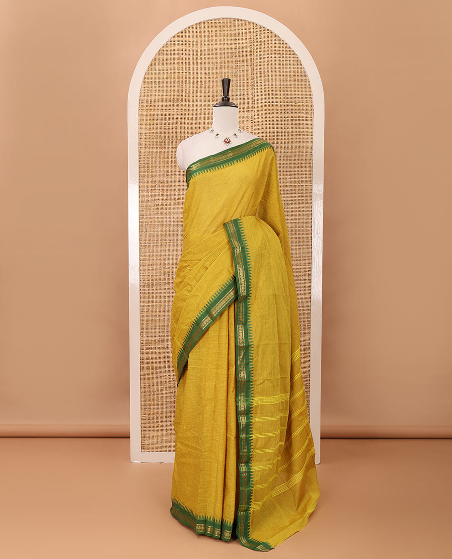 Mustard color plain design chettinadu cotton saree, contrast temple traditional design border, striped pallu & batik-printed blouse