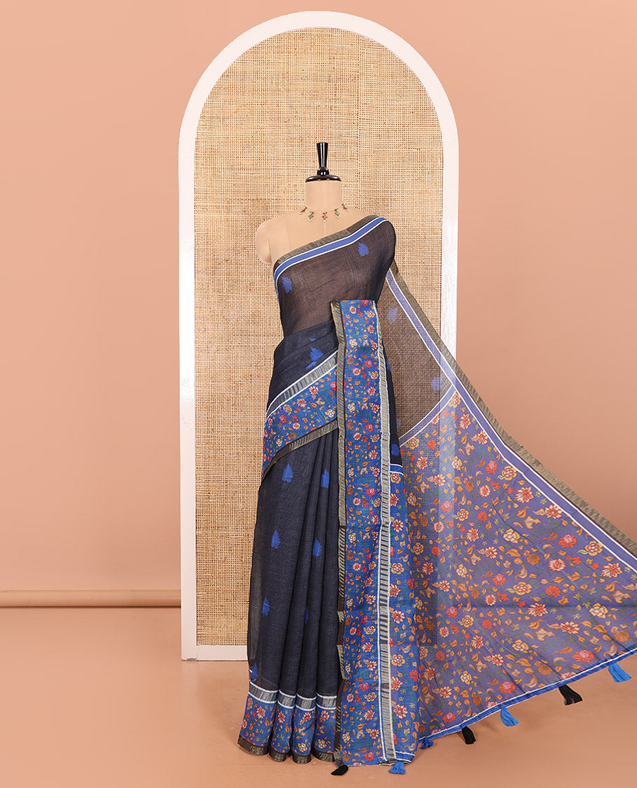 Black Linen Saree Adorned with Leaf Motifs All Over Its Body, Complemented by a Contrast Floral Vine Printed Border, Pallu Mirrors the Floral Vine Print, and Paired with a Contrast Floral Printed Blouse