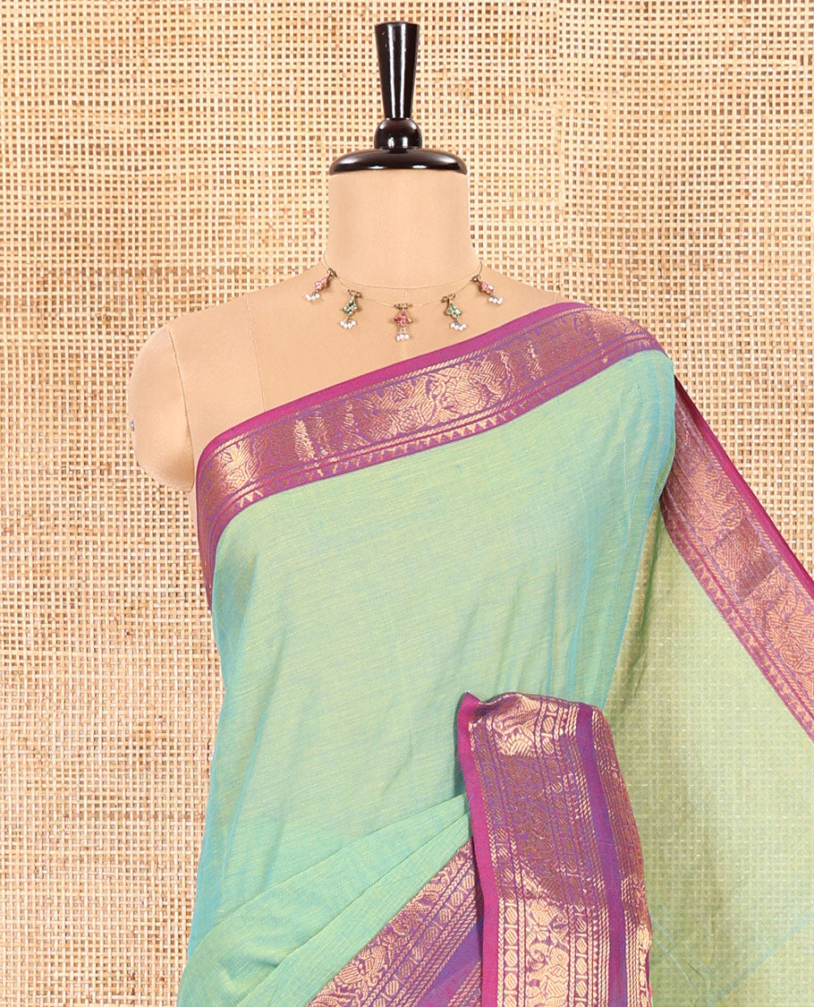 Pista Green Plain Chettinad Cotton Saree Decked Up with a Contrasting Temple Rettai Pettu Border of Peacock-Elephant Motifs, a Subtle Pallu of Stripes, and a Matching Blouse