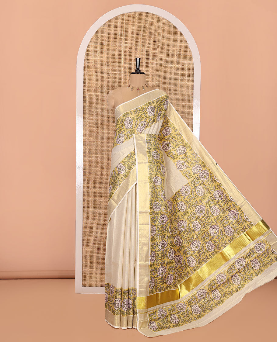 Cream Kerala Tissue Saree, Enriched with Floral Vine Motifs Printed on Its Body, Gleaming Golden Zari Border, Pallu Mirrors the Same Floral Vine Print, and Paired with a Matching Printed Blouse