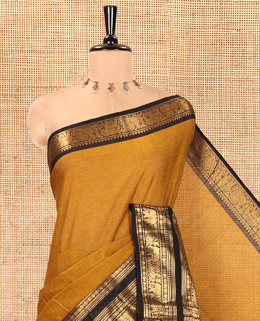 Mustard Plain Chettinad Cotton Saree, Complemented by a Contrast Rettai Pettu Temple Gold Zari Border of Coin, Elephant, and Peacock Designs, Subtly Striped Pallu, and Paired with a Matching Blouse