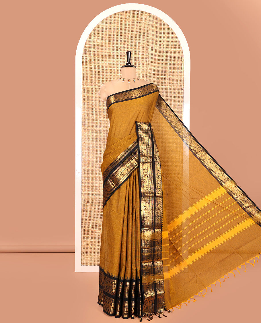 Mustard Plain Chettinad Cotton Saree, Complemented by a Contrast Rettai Pettu Temple Gold Zari Border of Coin, Elephant, and Peacock Designs, Subtly Striped Pallu, and Paired with a Matching Blouse