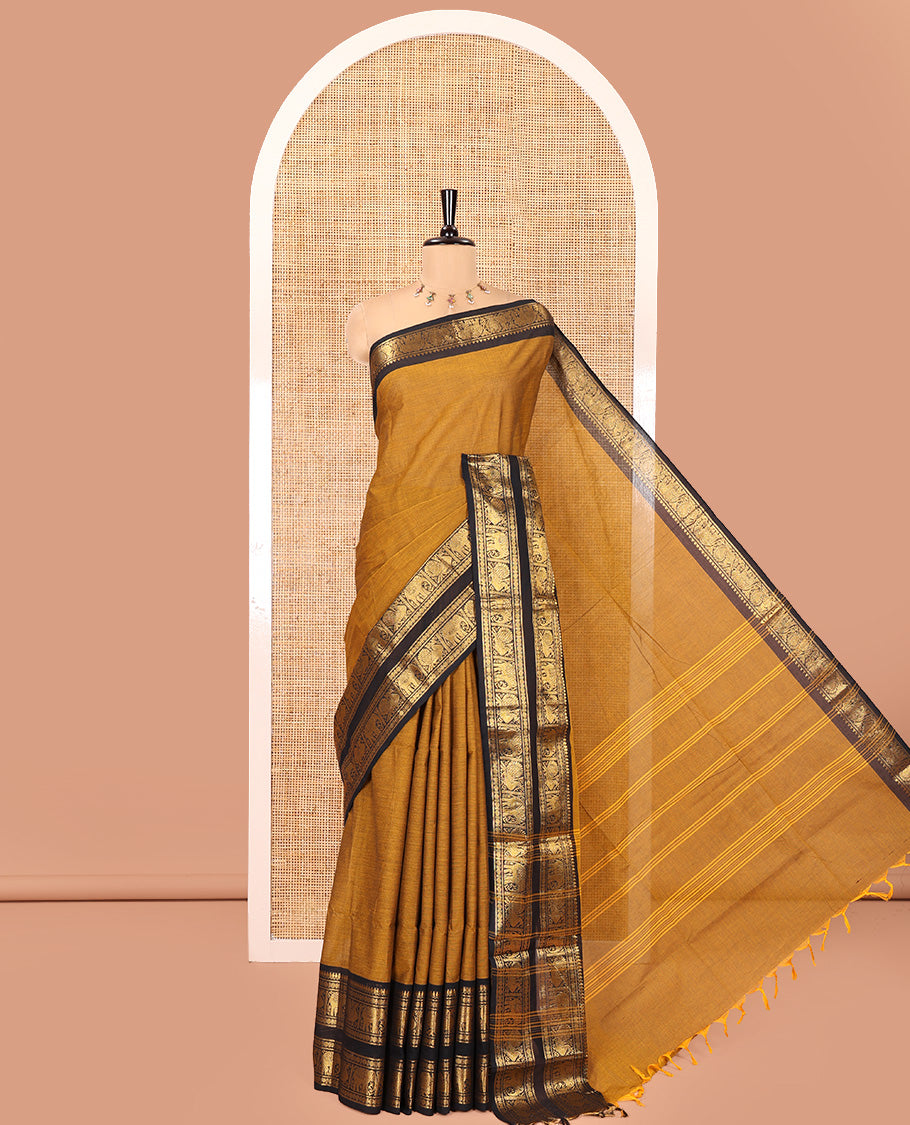 Mustard Plain Chettinad Cotton Saree, Complemented by a Contrast Rettai Pettu Zari Border of Thilakam Mokku, Rudraksham, Elephant, and Peacock Designs, Subtly Striped Pallu, and Paired with a Matching Blouse
