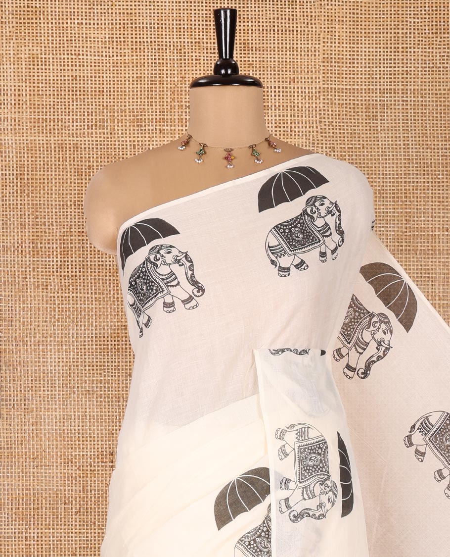 Cream Plain Kerala Cotton Saree, Creatively Printed with Elephant With Umbrella Motifs On Its Border, Pallu Steeped with Same Motifs Print, and Paired with a Matching Blouse