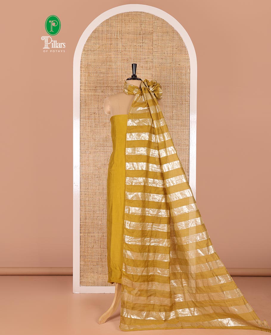 Mustard material chudidar set, plain with pom-pom tasseled mul chanderi top, a matching bottom, and organza dupatta of stripes