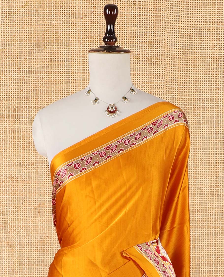 Mango yellow half-&-half style modal satin saree features floral & geometric Ajrakh printed contrast border & pallu