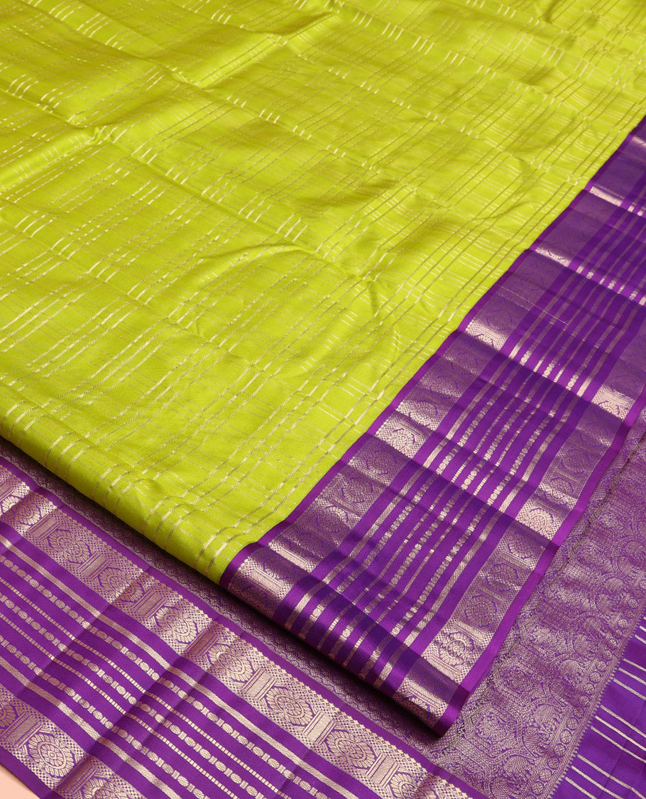 Green Vasundhara Silk Saree, Spotlighted with Zari Checked Design All Over Its Body, Complemented by a Contrast Varisai Pettu Border of Muthu, Poun, and Chakram Designs, Grandly Embellished Pallu of Jaal Designs, and Paired with a Contrast Blouse