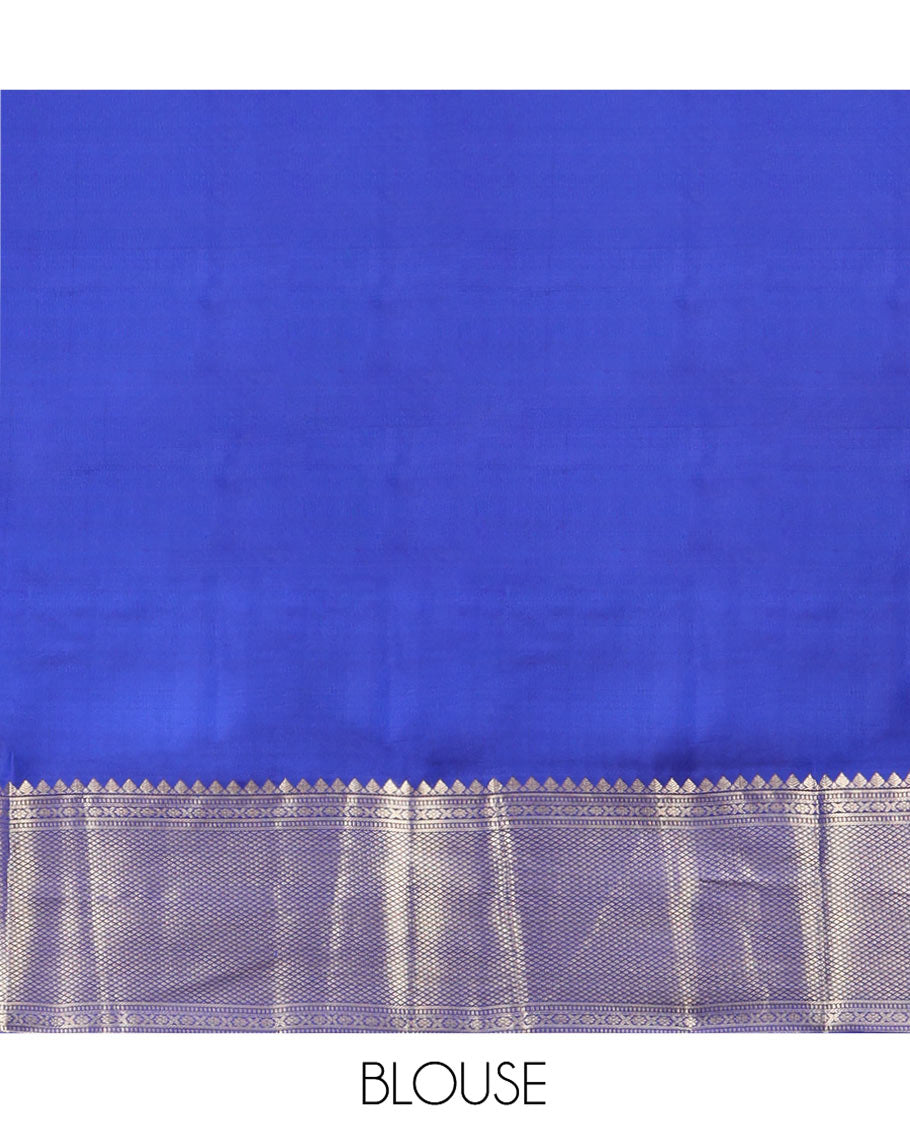 Blue Vasundhara Silk Saree Gleamed with Zari Buttas All Over Its Body, Highlighted with a Zari Border of Thilakam Mokku, Muthu, Cross Kamalam, and Mayil Kann Designs, Grand Pallu of Jaal Design, and Paired with a Matching Blouse