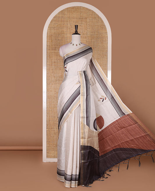 Cream leaf themed printed soft tussar saree, contrast golden zari horizontally striped border, dual color textured pallu, and contrast plain blouse