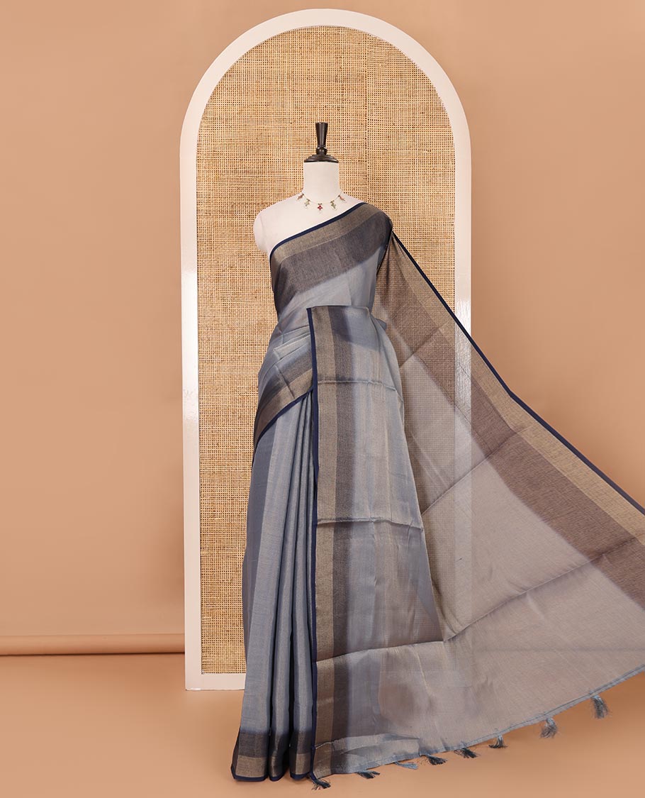 Grey plain tissue saree, contrast gold zari piping border & self pallu with tussels