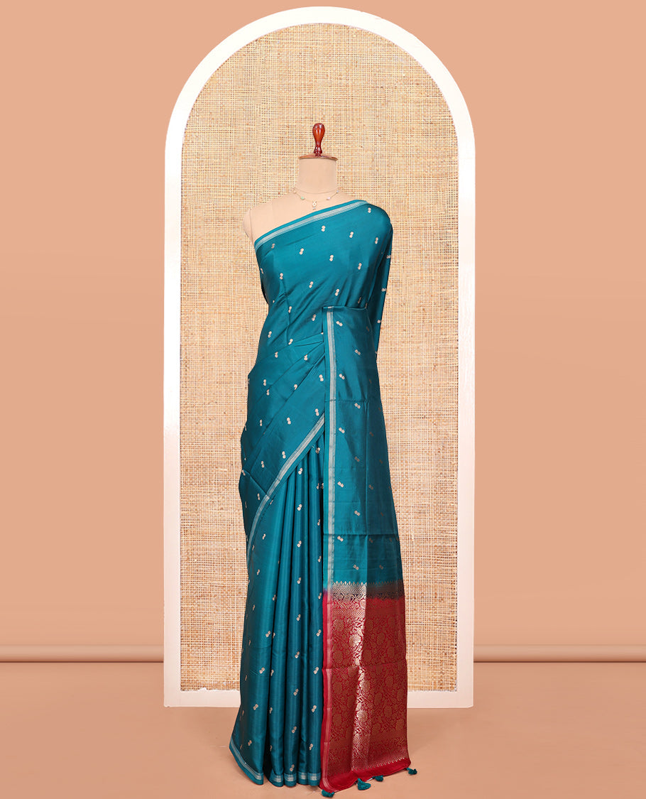 Peacock Blue Satin Silk Saree, Enthralled with Buttas All Over Its Body, a Subtle Piping Border, Complemented by a Contrast Pallu of Floral-Paisley Designs in Zari, and Paired with a Contrast Blouse