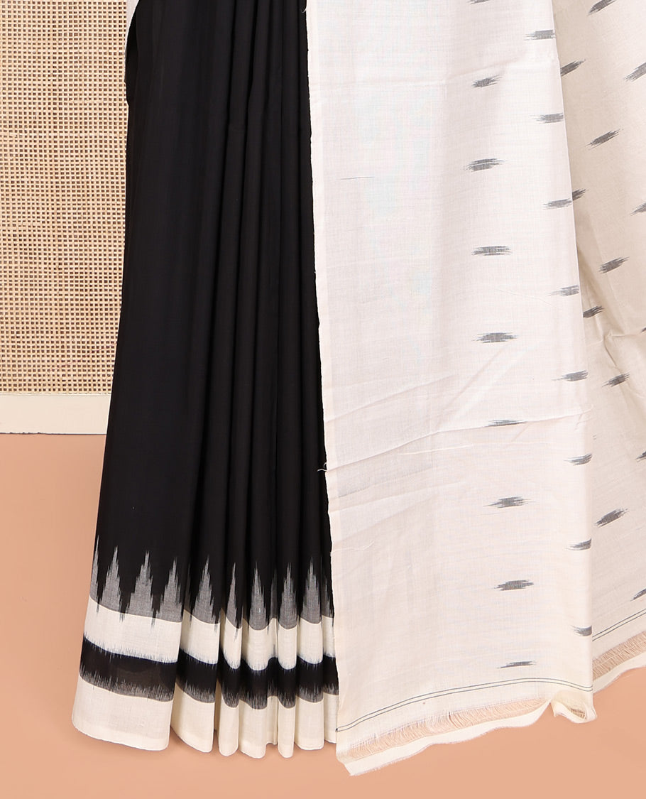 Black Plain Ikkat Cotton Saree, Complemented by a Contrast Ikkat Temple Border, Pallu Steeped with Buttas, and Paired with a Contrast Blouse