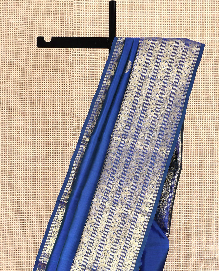 Blue Kanchipuram Silk Saree, Decorated with Zari Buttas All Over Its Body, Highlighted by a Zari Border of Salngai, Muthu, Mayil, and Kuthirai Designs, Grand Jaal Pallu, and Paired with a Matching Blouse