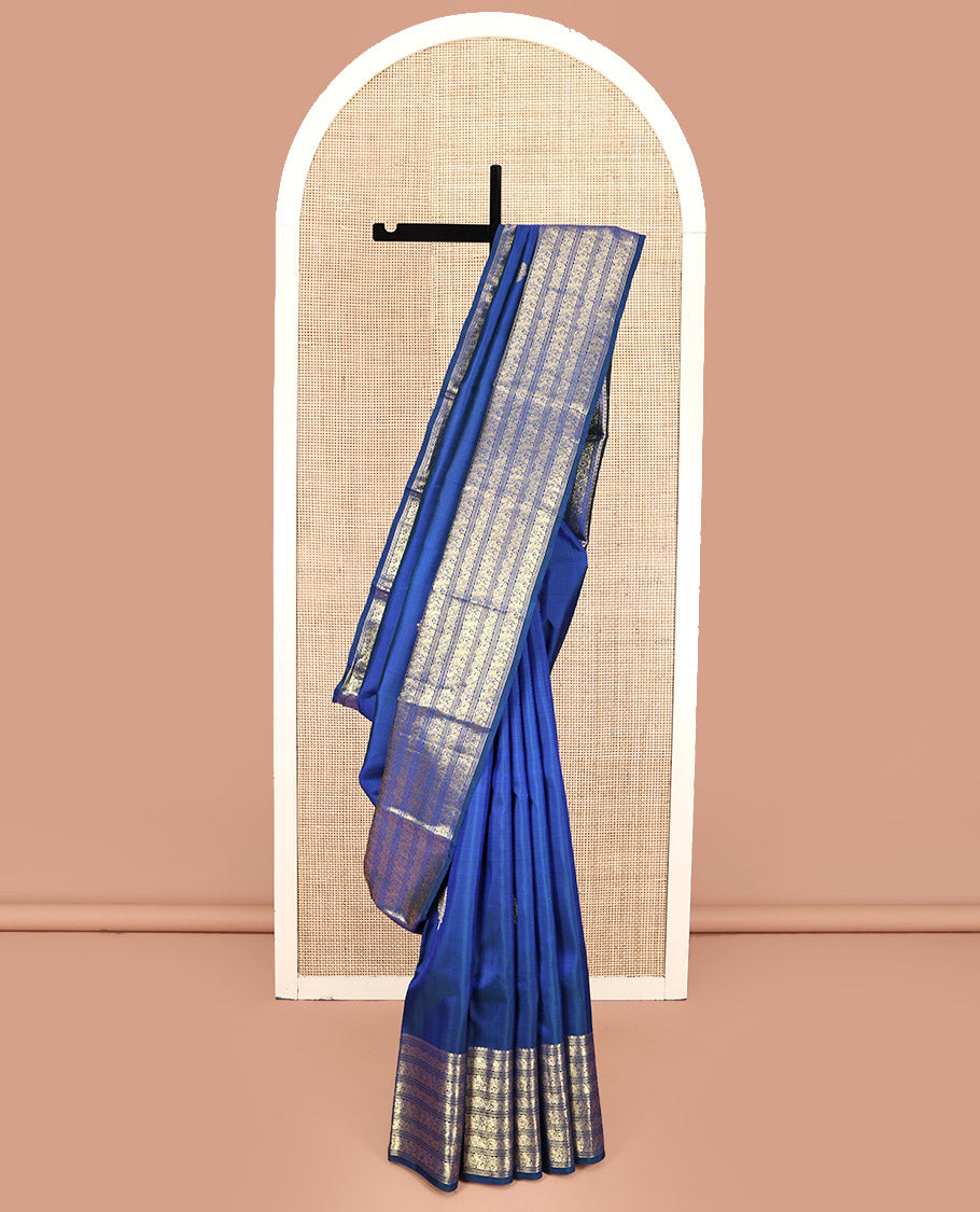 Blue Kanchipuram Silk Saree, Decorated with Zari Buttas All Over Its Body, Highlighted by a Zari Border of Salngai, Muthu, Mayil, and Kuthirai Designs, Grand Jaal Pallu, and Paired with a Matching Blouse