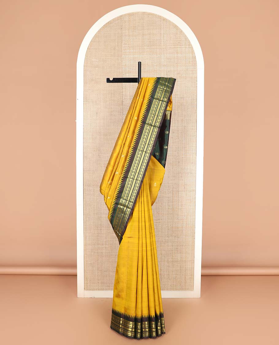 Yellow zari buttas Kanchipuram silk saree, contrast one-sided thazampoo rekku border of thilakam mokku, banaras, rudraksham and vanki designs, and zari design pallu
