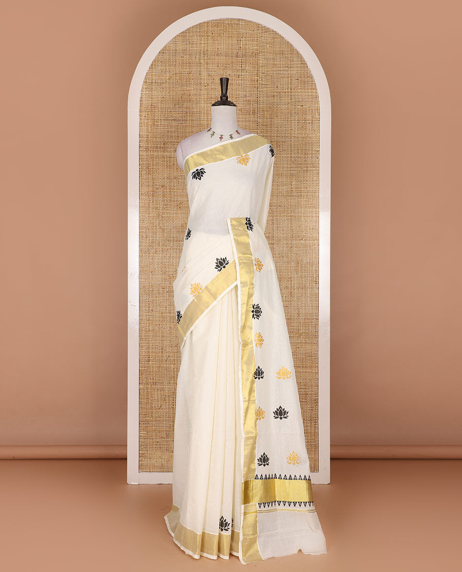 Half-white lotus motifs printed Kerala cotton saree, gold zari border, lotus motifs printed pallu, and matching blouse