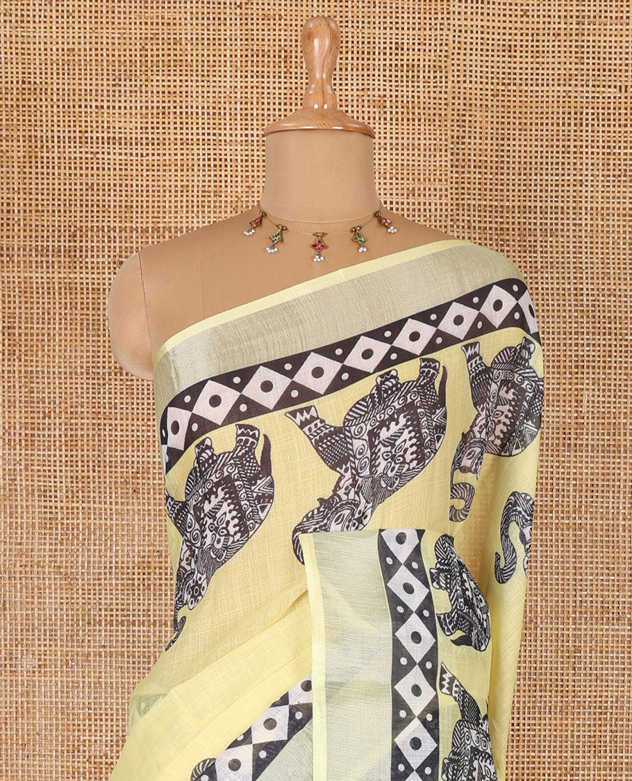 Yellow plain linen cotton saree, silver zari border of elephant motifs print, elephant motifs pallu, and a contrast elephant motifs printed blouse
