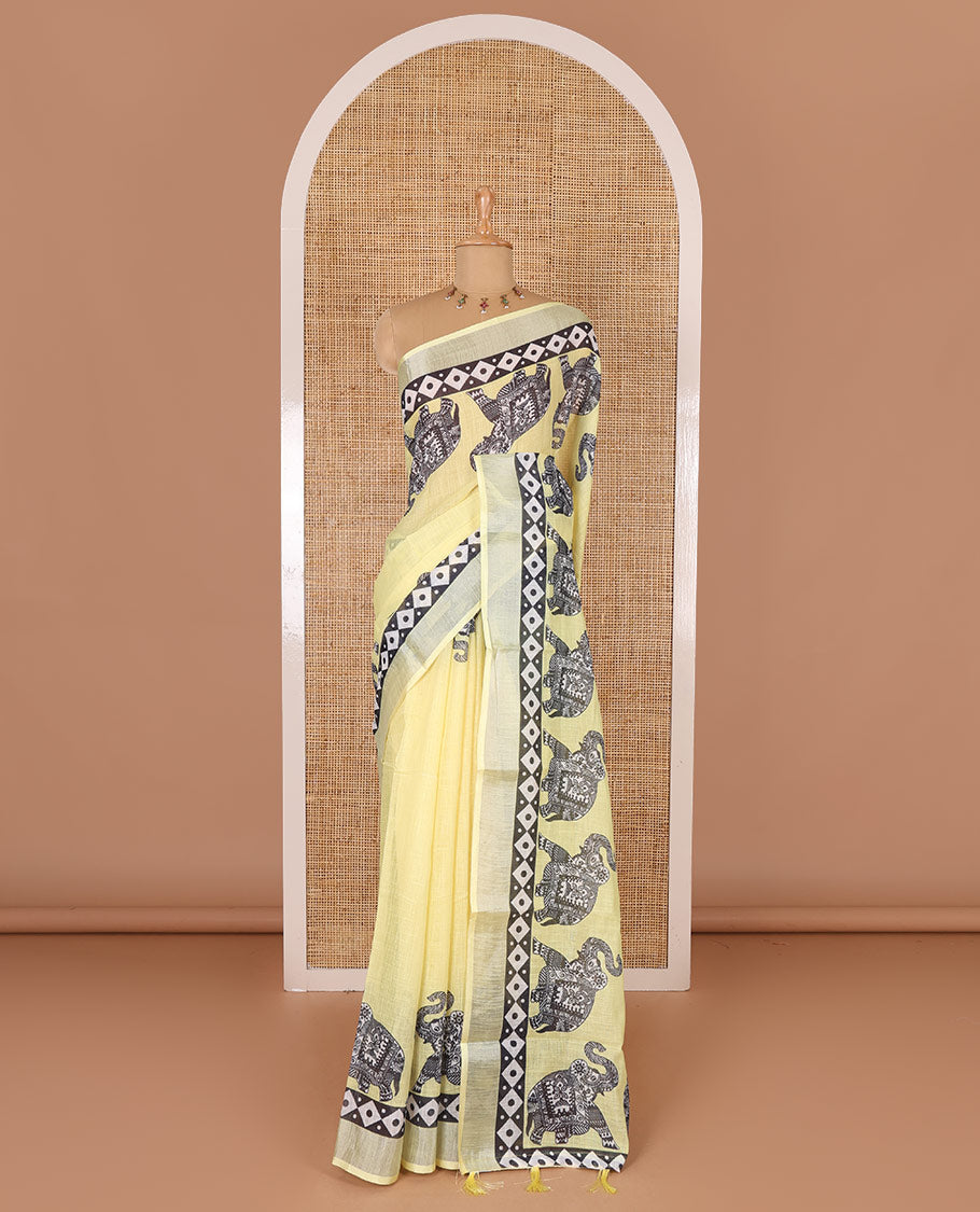 Yellow plain linen cotton saree, silver zari border of elephant motifs print, elephant motifs pallu, and a contrast elephant motifs printed blouse