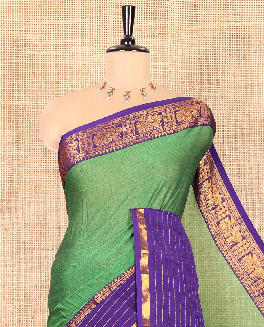 Green Plain Mercerised Cotton Saree, Complemented by Captivating Contrast-Colored Traditional Zari Varisai Pettu Border of Peacock Designs, Subtly Striped Pallu, and Paired with a Matching Blouse