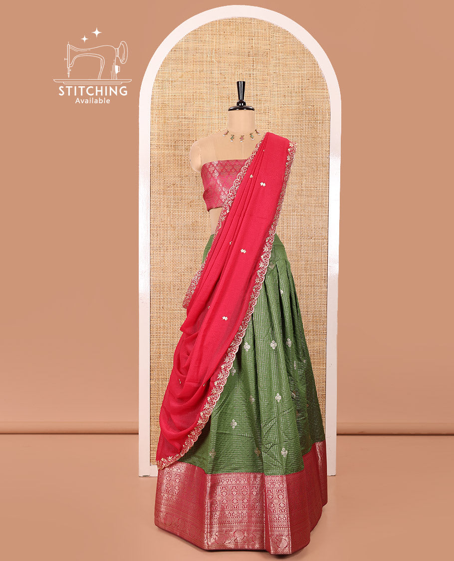 Green and Red Banaras Silk Half-Saree Featuring Zari Checks and Zari Buttas All Over the Skirt, Complemented by Contrast Traditional Zari Design Border, Paired with a Jacquard Blouse, and a Rangoli Georgette Dhavani of Embroidery and Scallop Border