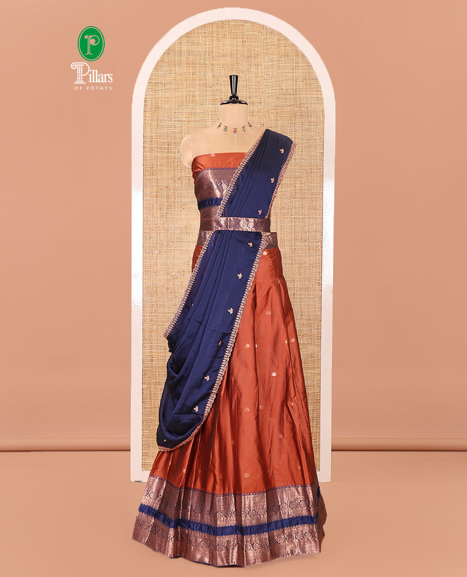 Rust and Blue Semi-Banarasi Half-Saree Featuring Zari Buttas Skirt, Complemented by Contrast Rettai Pettu, Traditional Border of Floral Creeper Designs, Paired with a Matching Blouse, and a Satin Georgette Embroidered Scallop Dhavani