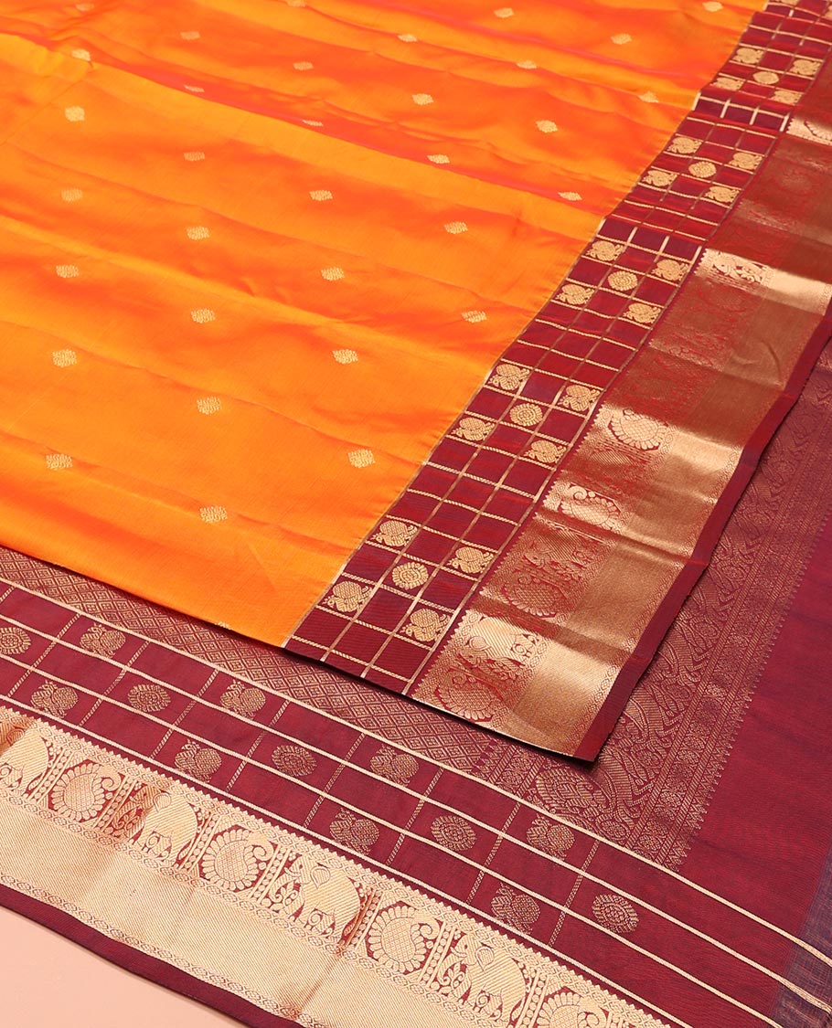 Orange Vasundhara Lite-Silk Mix Saree, Enthralled with Zari Buttas All Over Its Body, Complemented by a Contrast Annam Chakram Enclosed Checked Border of Kamalam, Manga, and Yaanai Designs, Grand Pallu of Jaal Designs, and Paired with a Contrast Blouse