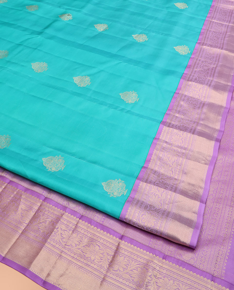 Blue Vasundhara Silk Saree Richly Detailed with Zari Buttas, Complemented by a Contrast Border of Thilakam Mokku, Kathir, Rudraksham, and Kodi Visiry Designs, Zari Designs Elevated Pallu, and Paired with a Contrast Zari-Bordered Blouse