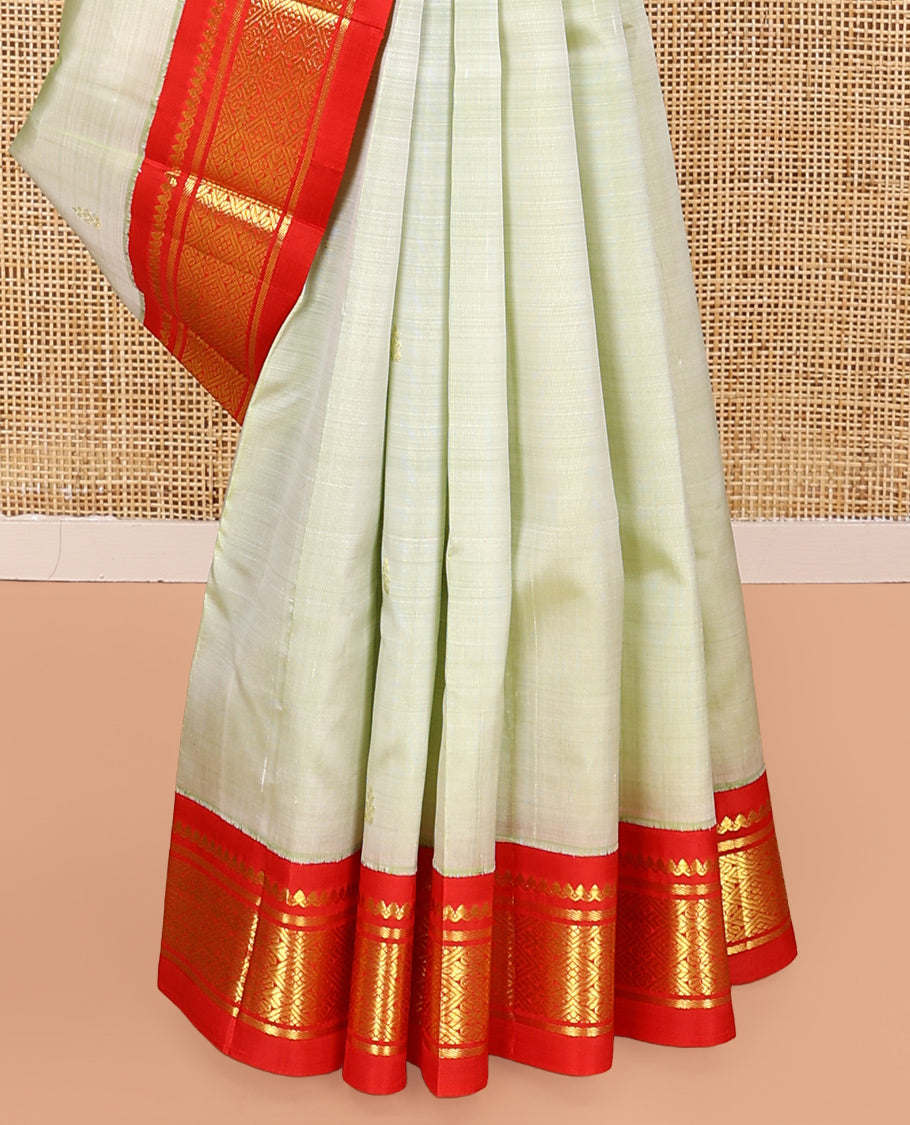 Pale Green Kanchipuram Silk Saree, Mesmerized with Zari Buttas All Over Its Body, Complemented by a Contrast One-Sided Korvai Border of Thilakam Mokku, Banaras, and Jaal Designs, Pallu of Zari Designs, and Comes Without a Blouse
