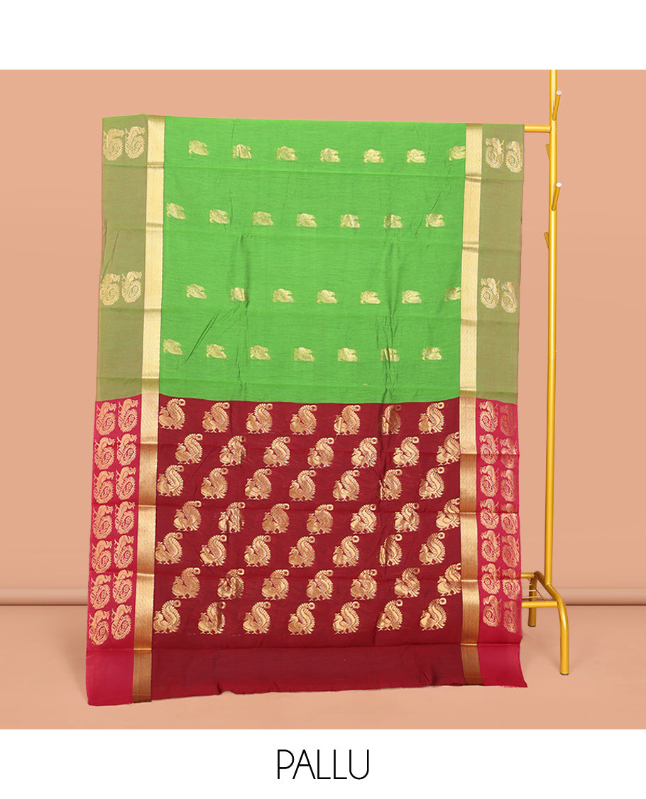 Green Semi-Silk Cotton Saree, Decked Up with Peacock Buttas All Over Its Body, Highlighted by a Zari Border, Pallu Artfully Woven with Peacock Designs, and Paired with a Contrast Blouse