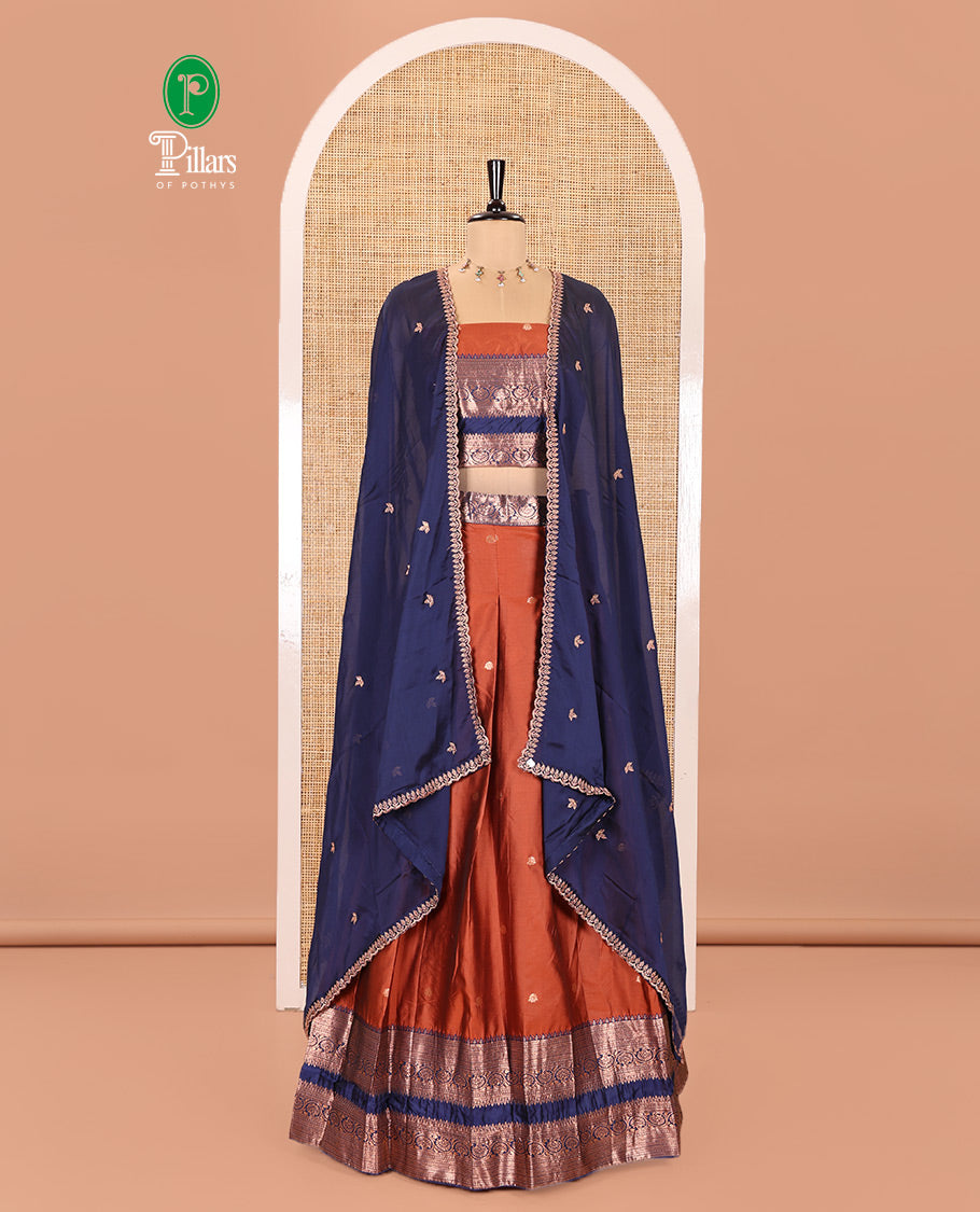 Rust and Blue Semi-Banarasi Half-Saree Featuring Zari Buttas Skirt, Complemented by Contrast Rettai Pettu, Traditional Border of Floral Creeper Designs, Paired with a Matching Blouse, and a Satin Georgette Embroidered Scallop Dhavani