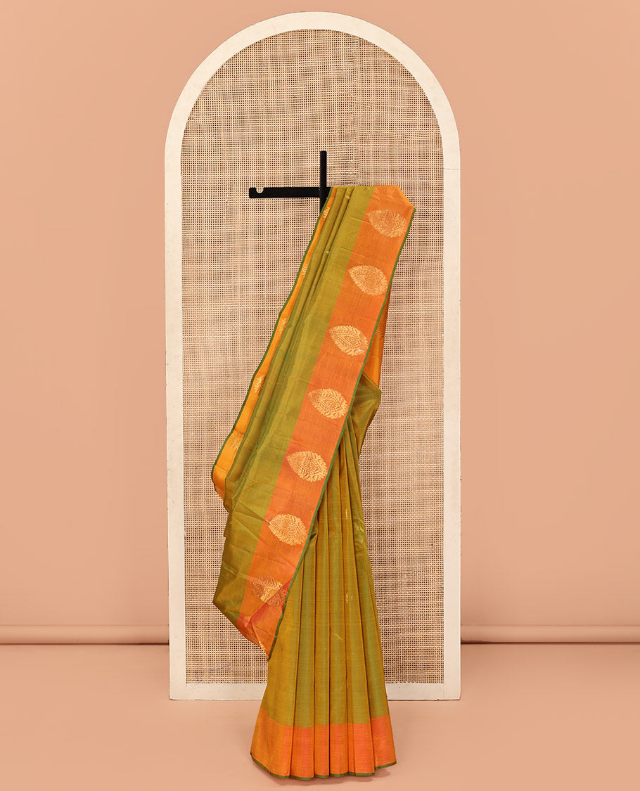 Green Kanchipuram Silk Saree, Sparsely Woven with Buttas All Over Its Body, Complemented by a Contrast Border of Thilakam Designs, Pallu Features Manga Zari Designs, and Paired with a Contrast Blouse