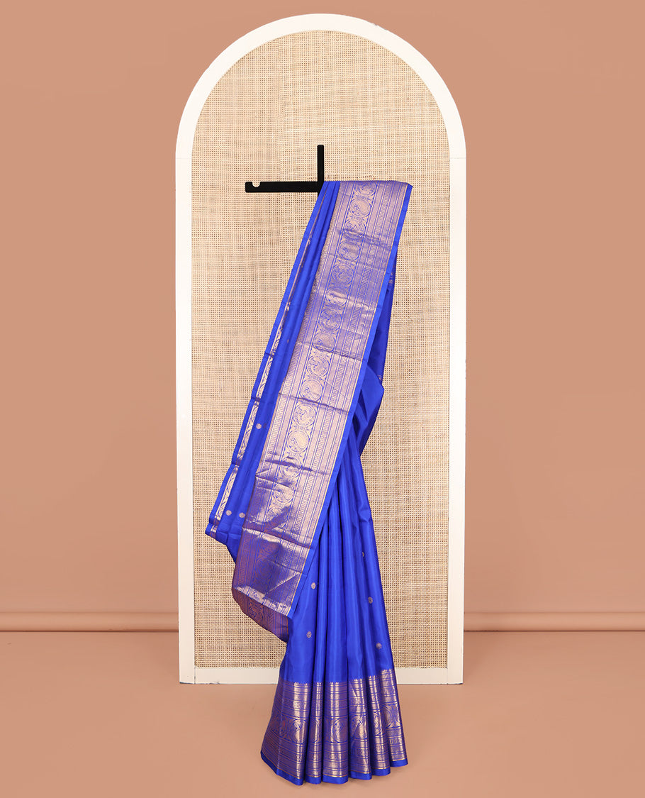 Blue Kanchipuram Silk Saree, Bedecked with Zari Buttas All Over Its Body, Highlighted by a Zari Border of Rekku, Vanki, Round Mayil, and Poun Manga Designs, Pallu of Zari Designs, and Paired with a Matching Blouse