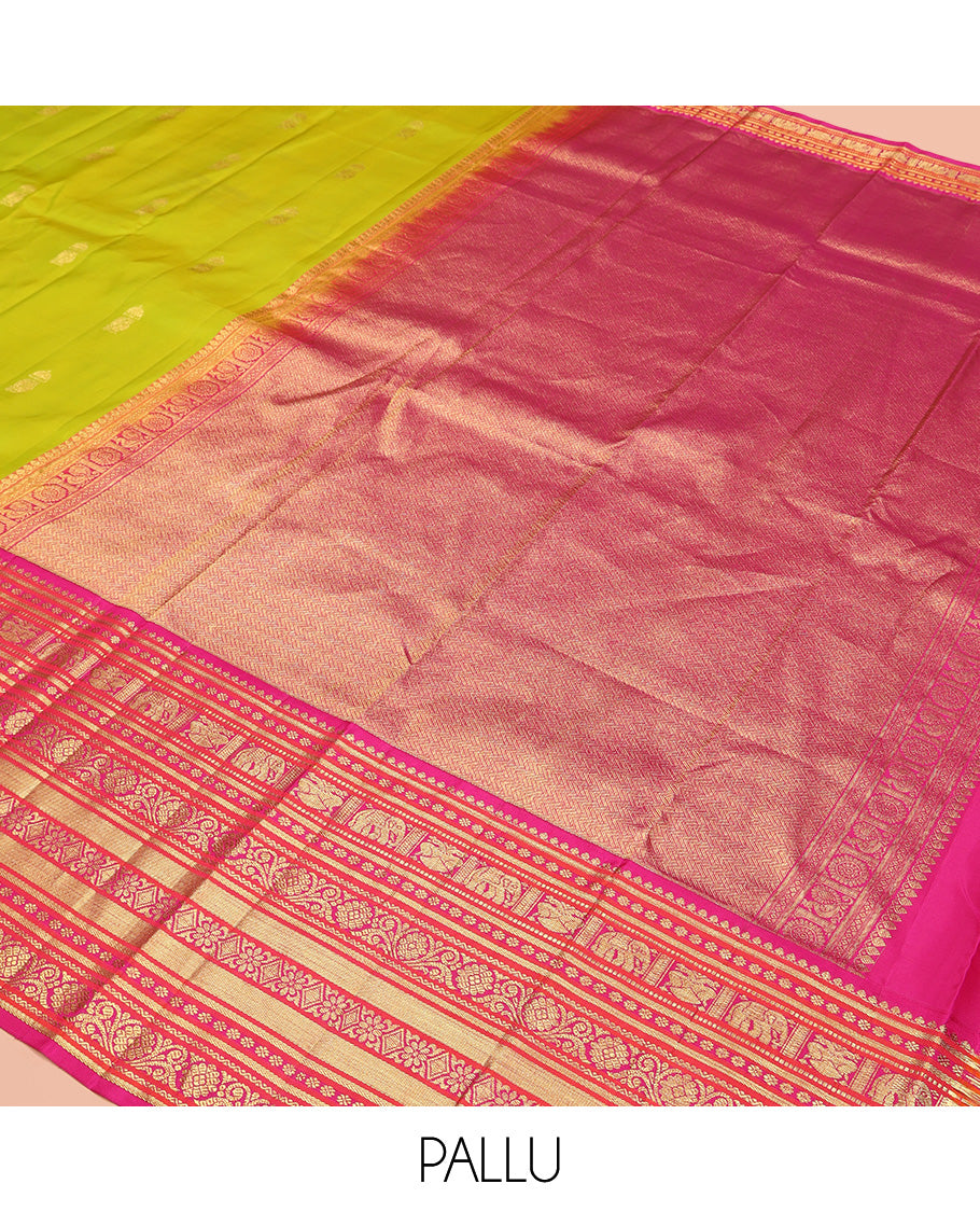 Green Vasundhara Silk Saree, Delicately Woven with Zari Buttas All Over Its Body, Complemented by Contrast Border of Thilakam Mokku, Kamalam, Iruthalai Pakshi, Yaanai, and Kamalam Designs, Vanki Design Pallu and Paired with a Contrast Blouse