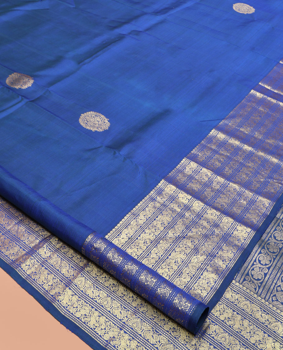 Blue Kanchipuram Silk Saree, Decorated with Zari Buttas All Over Its Body, Highlighted by a Zari Border of Salngai, Muthu, Mayil, and Kuthirai Designs, Grand Jaal Pallu, and Paired with a Matching Blouse